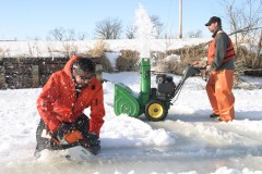 clearing snow and cutting ice to gain access to lake