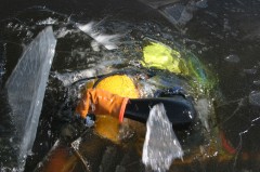diver breaking ice to emerge from lake