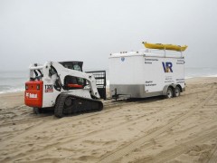 Bobcat hauling dive trailer to a new beach location