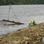 diver assists with underwater placement as crane lowers revetment mats