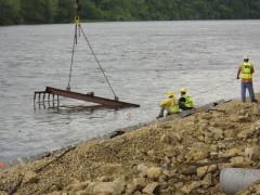 diver assists with underwater placement as crane lowers revetment mats