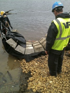 diver assists in positioning concrete revetment mats