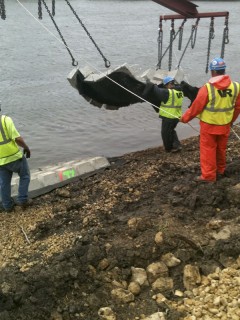 guiding above-water reventment mats into position